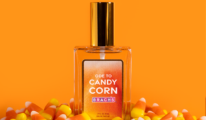 Brach’s Ode to Candy Corn eau de parfum bottle surrounded by candy corn against an orange background.